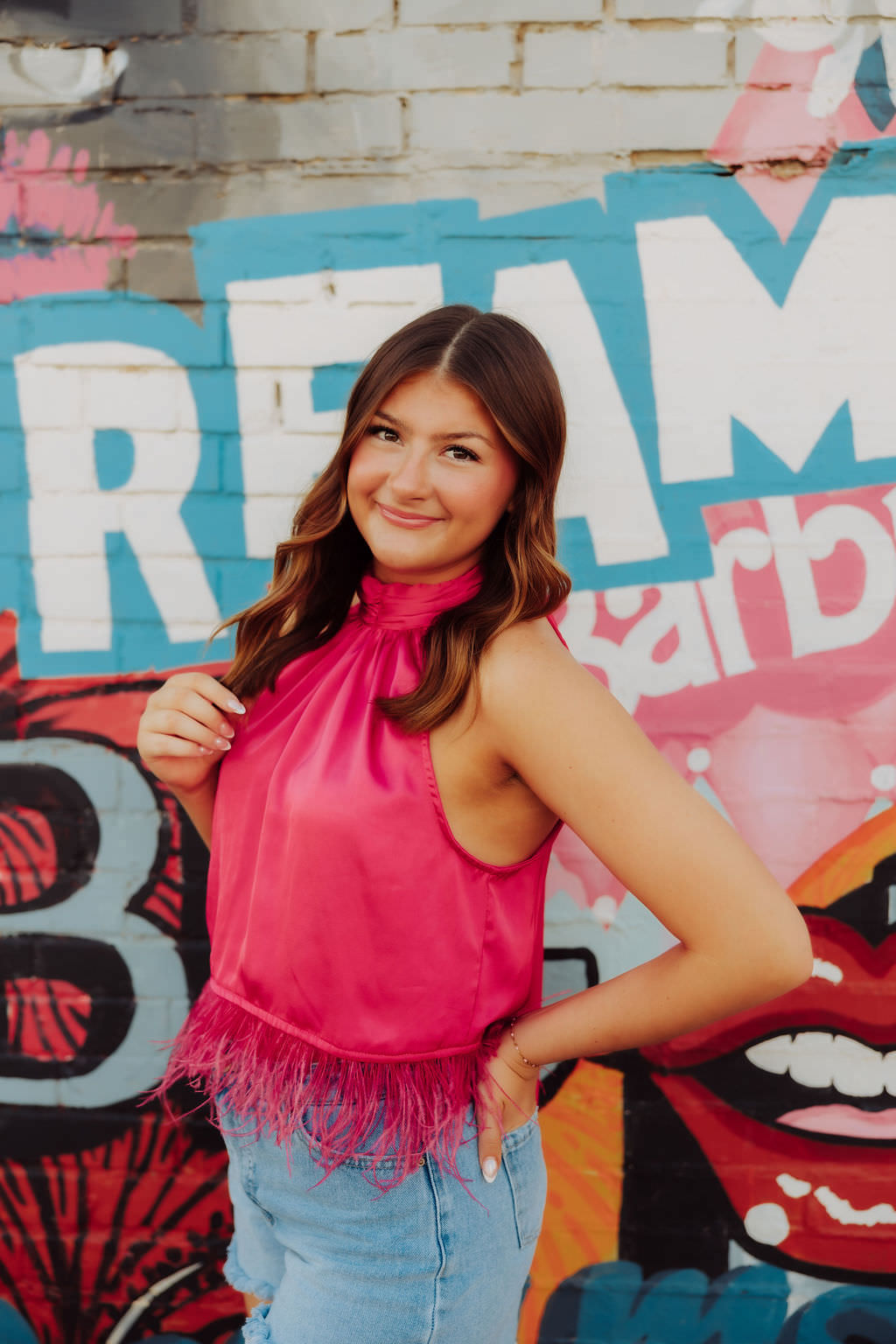 A girl in a hot pink top is smiling for the camera in downtown Altus